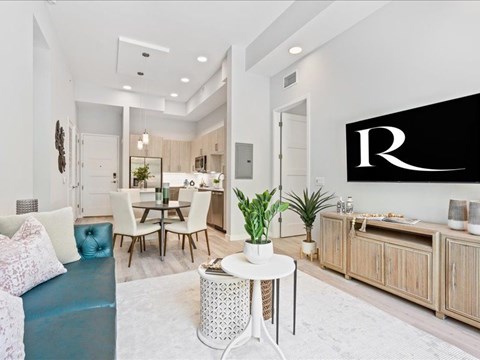 a living room with a couch and a table and a kitchen